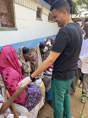 Dr. Taj helping people on a mission trip