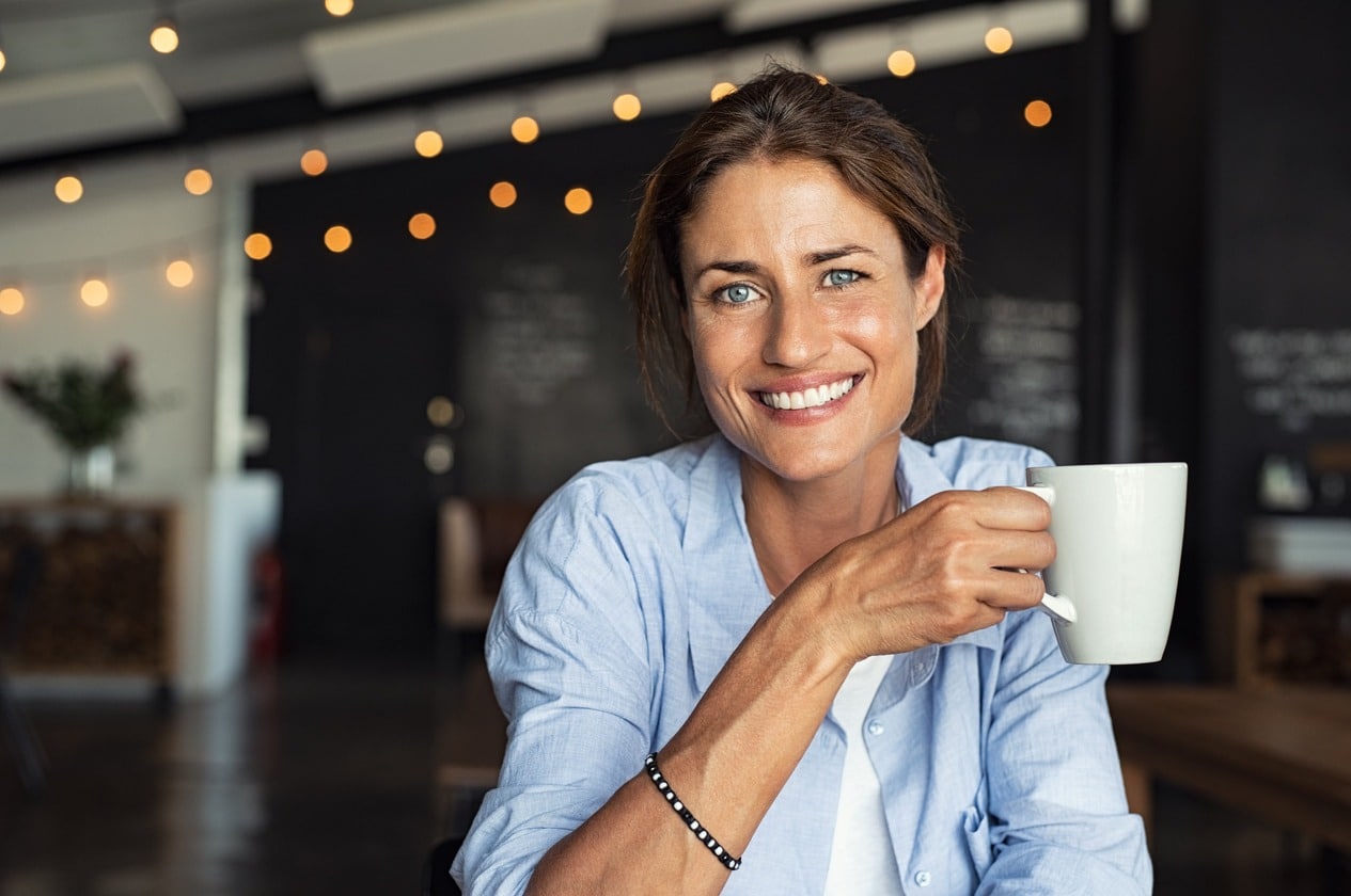 Woman holding coffee mug at a cafe